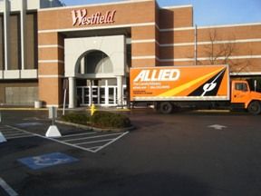 Delivery truck parked outside the entrance of a Westfield shopping mall.