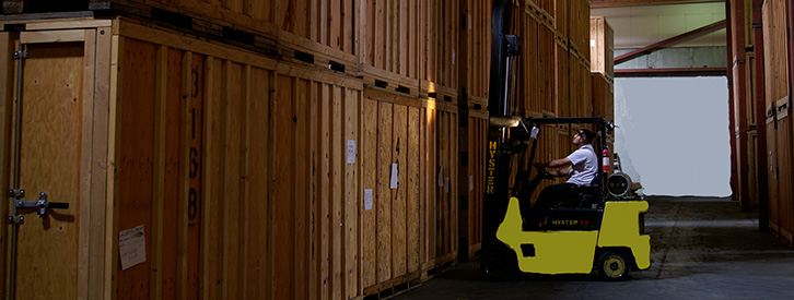 Employee operating a lifting fork in a portable self storage warehouse.