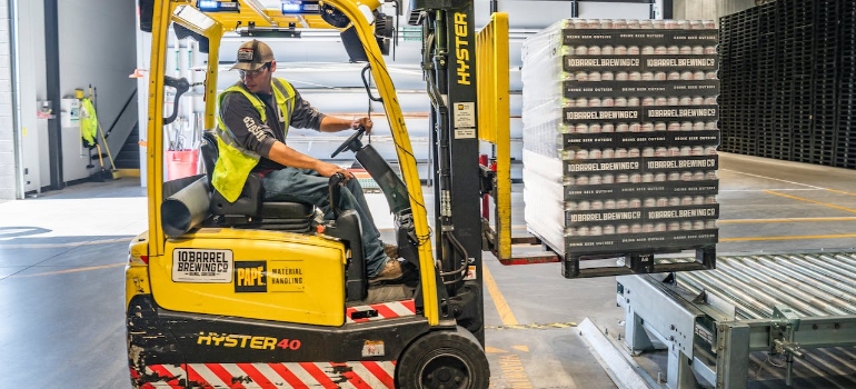 A man using forklift to provide palletizing services