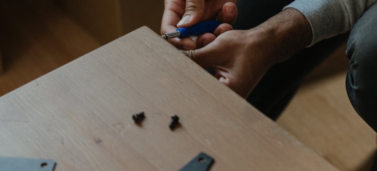 A person disassembling a table
