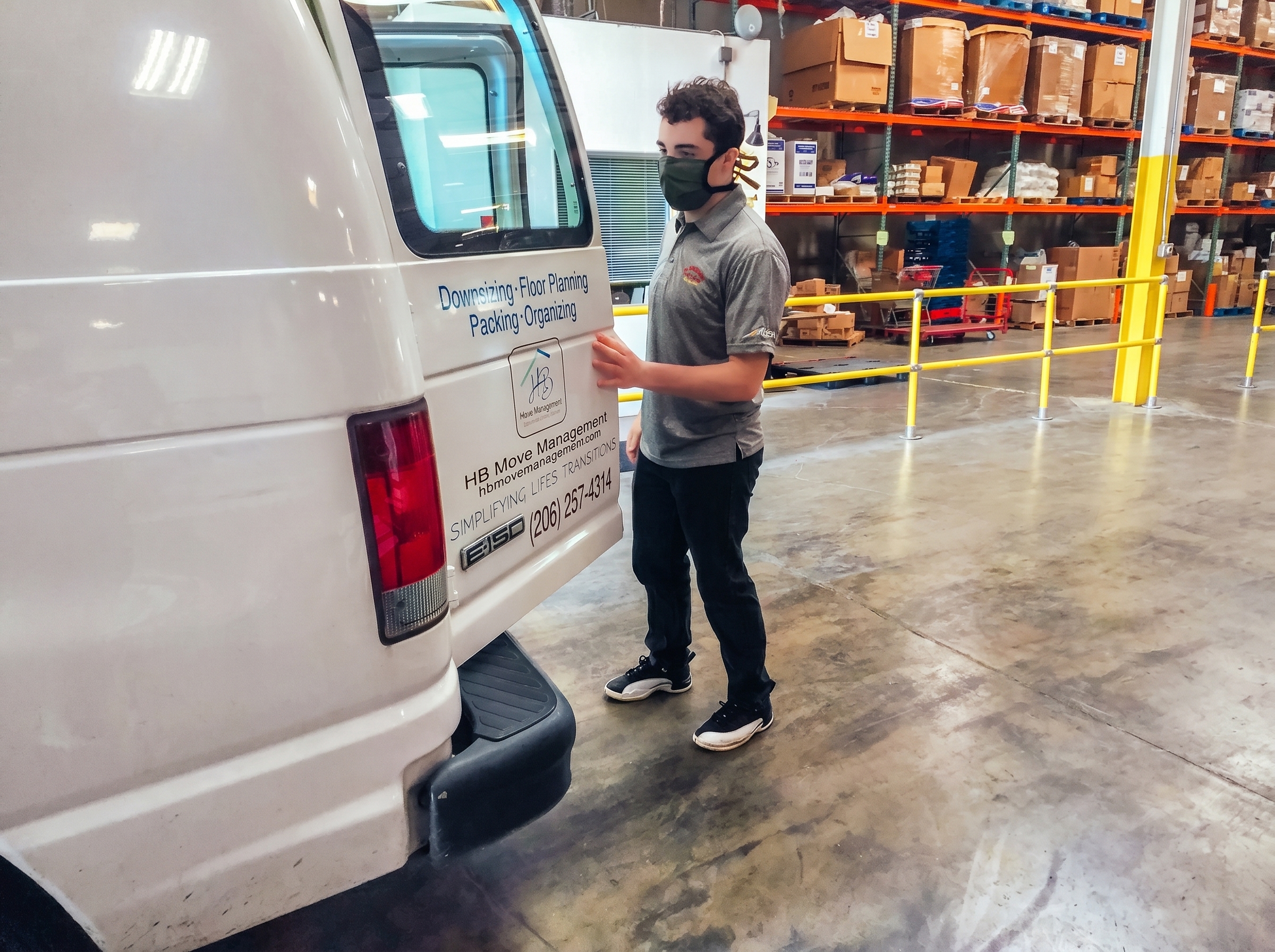 A man in bubble jacket holding tablet computer in a distribution and logistics warehouse